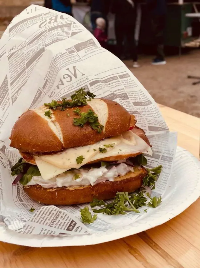 Bayrischer Burger im Laugen-Bun mit Leberkäse, Gouda, Fleischsalat und süßem Senf